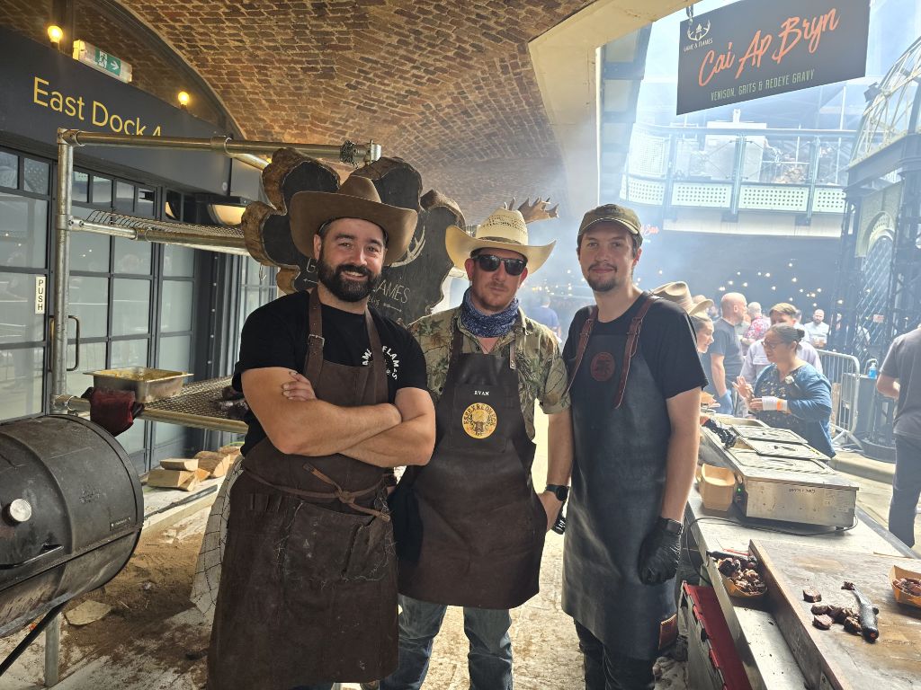 Cai and team posing at smoker with Game and Flames sign