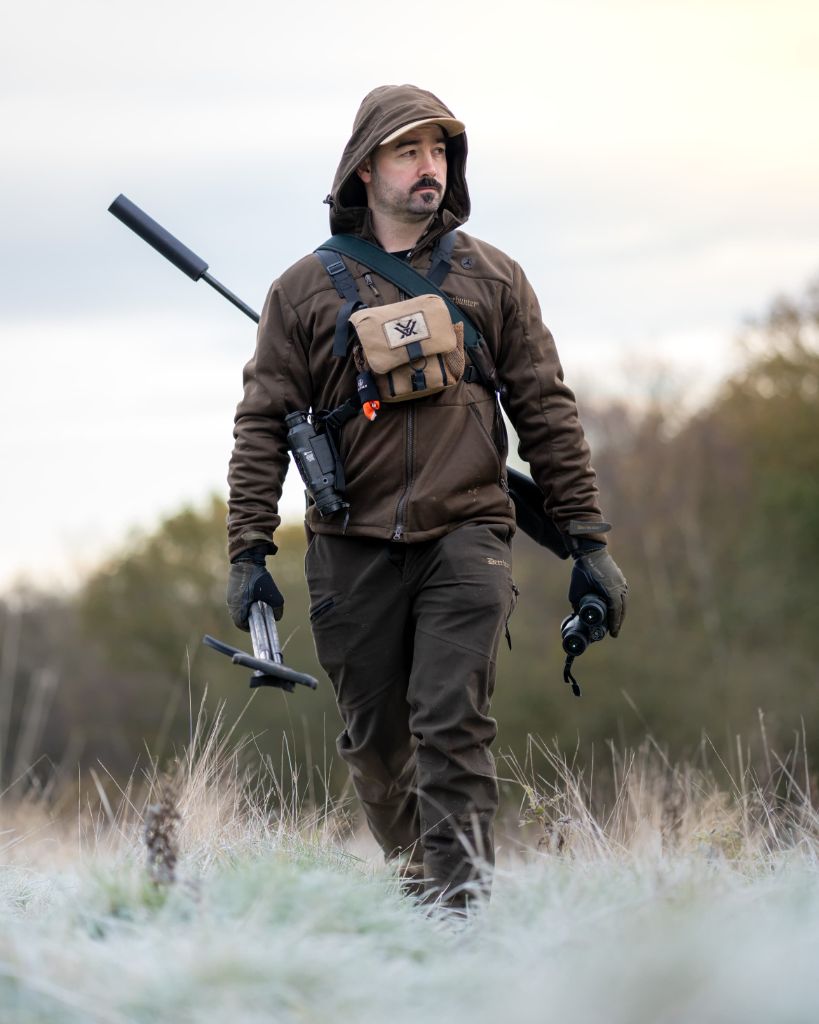 Cai Ap Bryn walking across a frosty field at dawn with full deer stalking kit