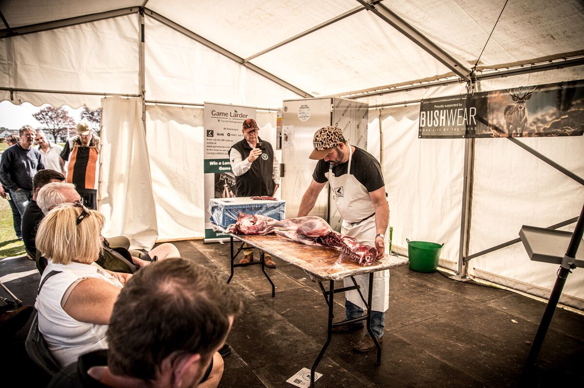Full workshop audience watching Cai demonstrate deer butchery in the marquee